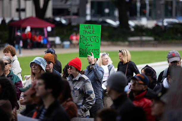 A protester holds a sign that reads, ''will trade racists for refugees'' during a demonstration against Immigration and Customs Enforcement (I.C.E.) outside City Hall in Houston, Texas,
