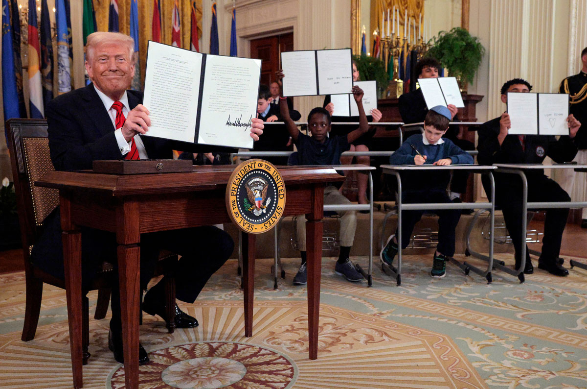 President Donald Trump and students display a signed executive order during a White House event in Washington, D.C., USA