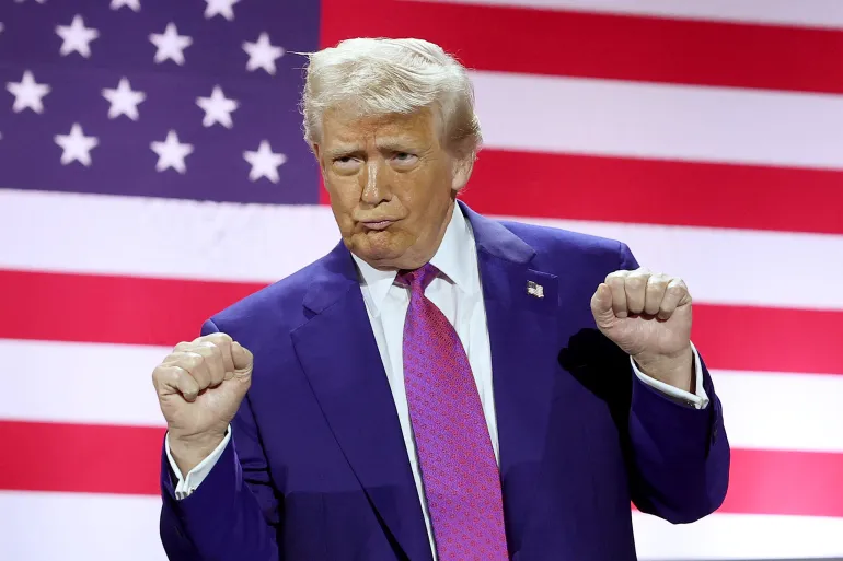 US President gestures on stage on May 15,2025 in Qatar.