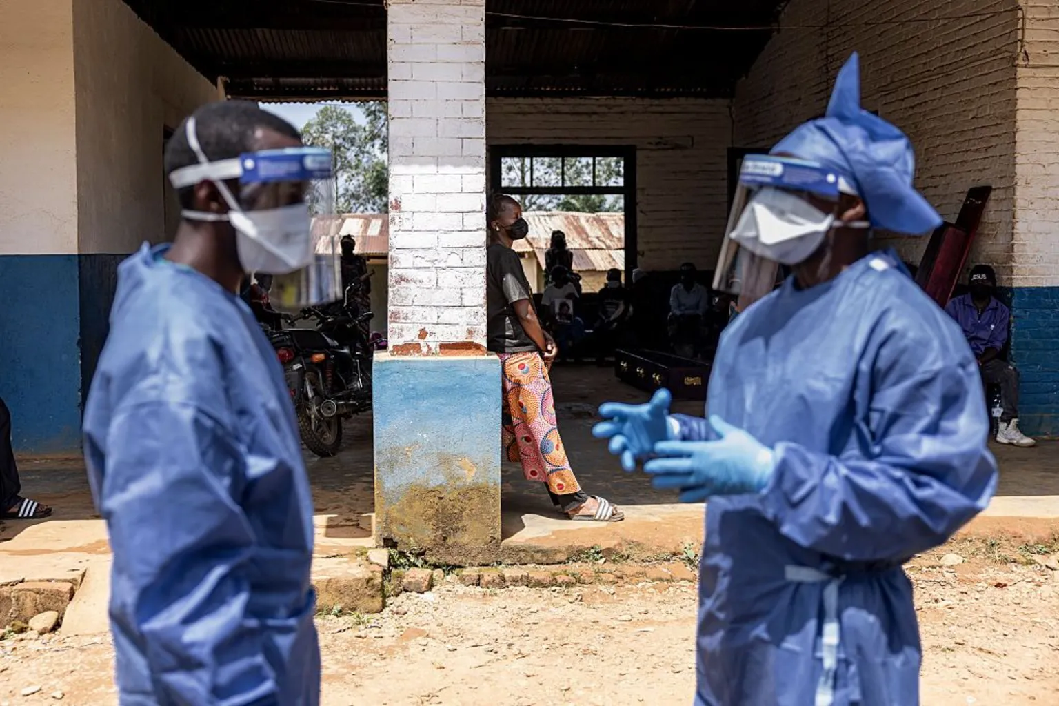 Health workers wearing protective equipment stand outside the General Referral Hospital during the Ebola outbreak