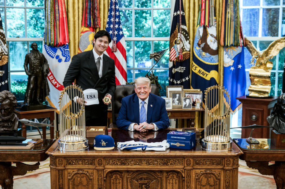 President Donald J. Trump poses with an unnamed professional baseball player at the Oval Office in Washington D.C.