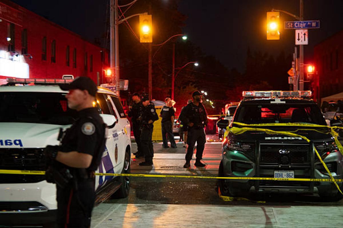 Police officers and other law enforcement personnel are seen at the intersection of St. Clair West and Arlington Avenue, near the site of a shooting that occured at the Salsa on St. Clair Festival in Toronto on the evening of July 11, 2026. Photo: Laura Proctor/AFP via Getty Images.