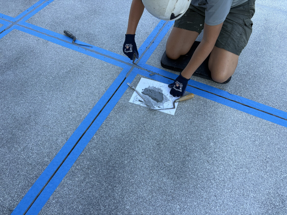 A worker applies grout to granite paving slabs at the White House North Entrance in Washington D.C. on 08/28/2026.