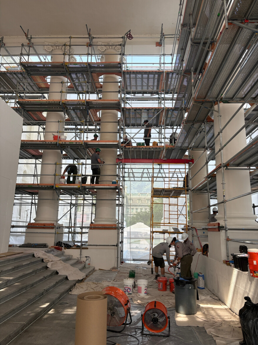 Tradesmen work on multi-level scaffolding to restore an ornate columned interior in Washington D.C. on 08/26/2026.