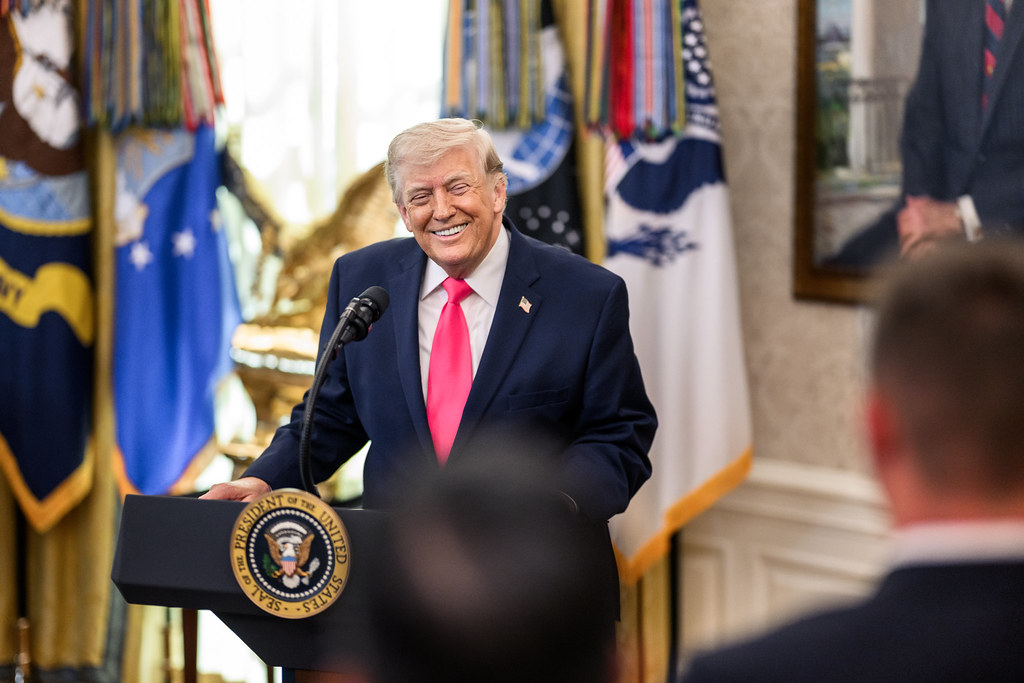 President Donald J. Trump points to a report at Washington D.C.